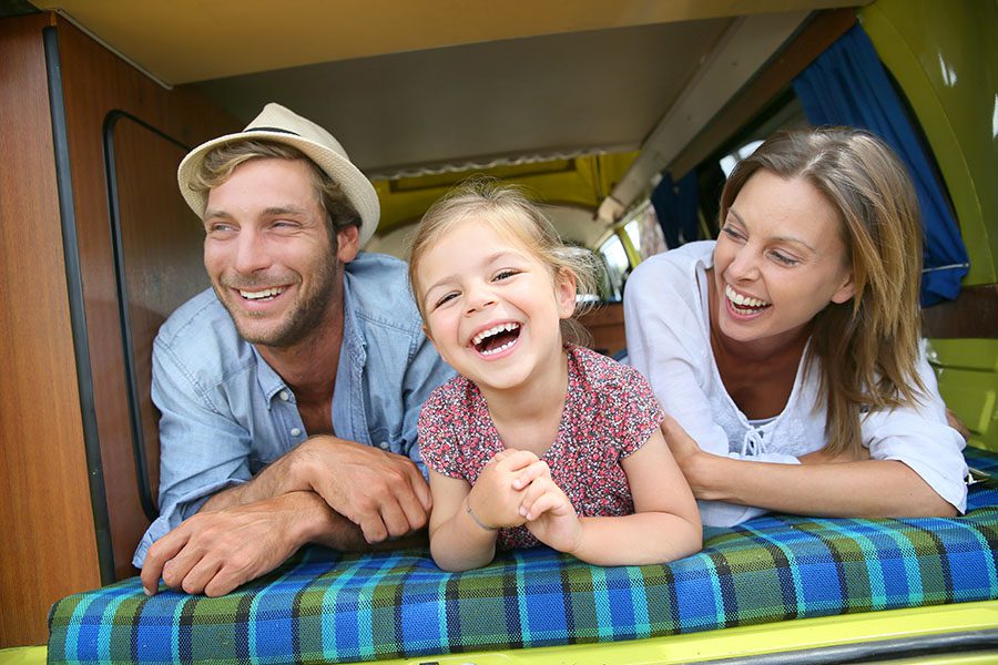 About Our Agency - Excited Parents And Daughter Having Fun Laying Down In Camper